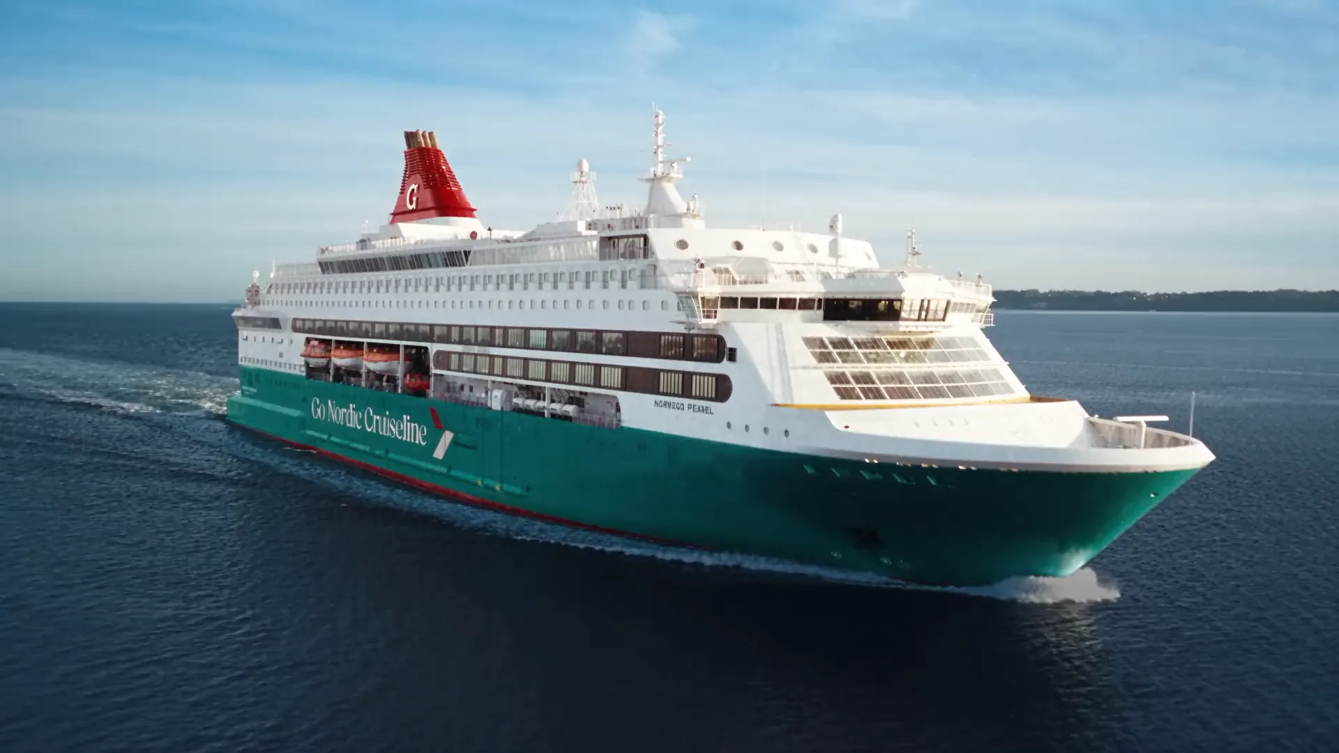 A Go Nordic Cruiseline ferry sailing on calm blue water on a clear day