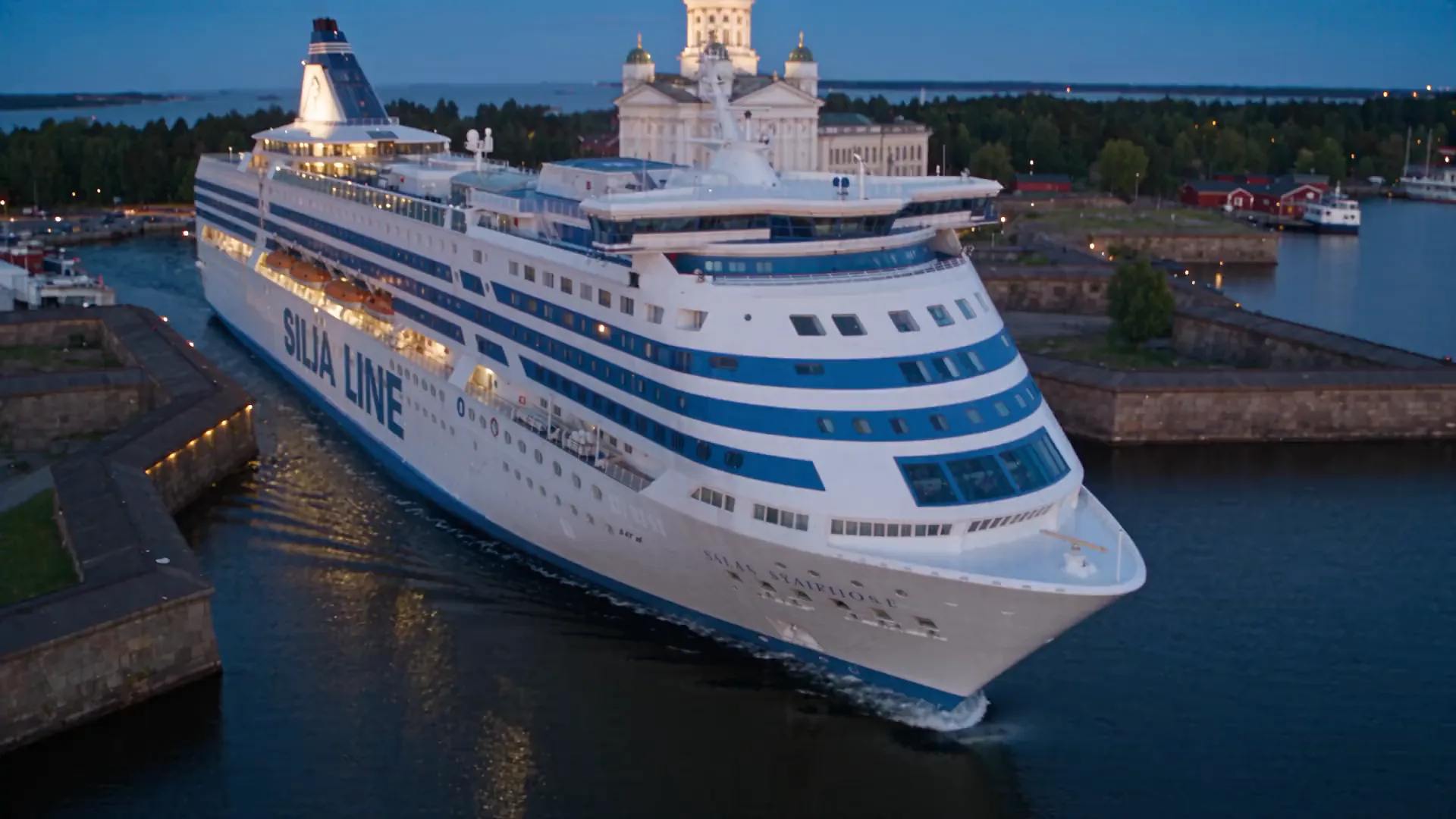 Aerial view of a Silja Line ferry leaving Helsinki at dusk, with the cathedral behind it