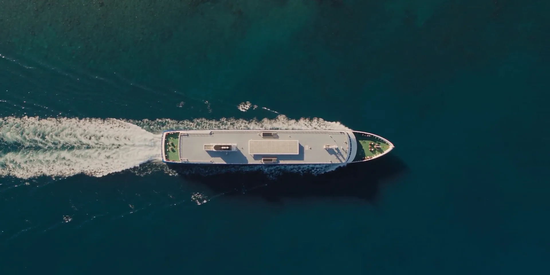 Aerial view of a ferry sailing across calm blue water